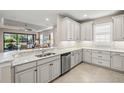 Spacious kitchen boasting stainless steel appliances, granite countertops, white cabinetry, and tile floors at 5556 Cantucci St, Nokomis, FL 34275