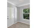 Cozy bedroom featuring a window with a view of the lush greenery outside, and a white door at 115 24Th W St, Bradenton, FL 34205