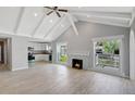 Bright, airy living room with vaulted ceilings, a fireplace, and large windows overlooking the lush greenery outside at 115 24Th W St, Bradenton, FL 34205