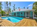 The private pool is surrounded by a wooden deck with a screened in porch and lush landscaping, offering a serene outdoor retreat at 115 24Th W St, Bradenton, FL 34205
