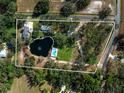 Aerial view of the property, highlighting its boundaries, pond, pool, house, and surrounding landscape at 1228 Wagon Wheel Dr, Sarasota, FL 34240