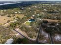 A sprawling estate with a serene pond and pool nestled among the trees, captured from an aerial view at 1228 Wagon Wheel Dr, Sarasota, FL 34240