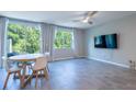 Open-concept living space with wood tile flooring, ceiling fan, and sliding glass doors to a patio at 17136 Blowfish Dr, Nokomis, FL 34275