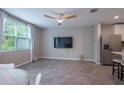 Bright living room with neutral paint, wood-look tile, ceiling fan and a view into the kitchen at 17136 Blowfish Dr, Nokomis, FL 34275