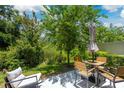 Inviting backyard patio with lush greenery, a dining table set, and comfortable seating for outdoor relaxation at 17136 Blowfish Dr, Nokomis, FL 34275