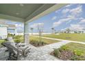 Inviting covered porch with stone pillars and comfortable seating overlooking a picturesque waterside view at 1944 Vang Ln, Sarasota, FL 34240