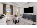 Comfortable living room with a large sectional sofa, modern decor, and a view to the backyard at 1944 Vang Ln, Sarasota, FL 34240