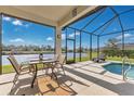 This screened-in patio area offers relaxing lounge and dining spaces and beautiful lake views at 3831 Creekside Park Dr, Parrish, FL 34219