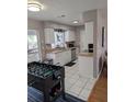 Bright eat-in kitchen with white cabinets, stainless appliances and a foosball table for added fun at 5876 Countrywood Dr, Sarasota, FL 34232