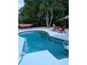 Relaxing backyard pool with seating and hammock in a tropical setting, perfect for outdoor enjoyment at 5876 Countrywood Dr, Sarasota, FL 34232