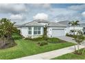 Attractive single-story home featuring a two-car garage, well-kept lawn, and manicured landscaping at 9978 Bright Water Drive, Englewood, FL 34223