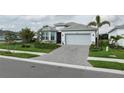 Beautiful single-story home with a paved driveway, manicured lawn, and well-maintained landscaping at 9978 Bright Water Drive, Englewood, FL 34223