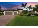 Charming single-story home with a three-car garage, lush lawn, and tropical landscaping at 16741 Ellsworth Ave, Bradenton, FL 34202