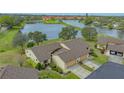 Exterior view of home with two-car garage, and a view of the serene lake at 3119 Glen Elyn Blvd # 9, Sarasota, FL 34237