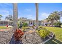 Charming home featuring tropical landscaping with palm trees and vibrant foliage in the front yard at 3672 Pine Rd, Venice, FL 34293