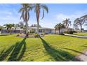 Well-maintained front yard with mature palm trees and lush green grass at 3672 Pine Rd, Venice, FL 34293