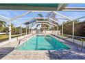 Refreshing pool with screened enclosure surrounded by lush landscaping for privacy and shade at 3672 Pine Rd, Venice, FL 34293