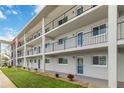 Exterior of building with balconies, black metal railings, well maintained lawn, and manicured flower beds at 649 S Tamiami Trl # 210, Venice, FL 34285