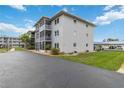 Condo building exterior features screened balconies, paved driveway, and well-maintained landscaping at 649 S Tamiami Trl # 210, Venice, FL 34285