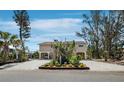 Inviting exterior view of stilted home with covered parking and attractive landscaping and plenty of room for parking at 650 Penfield St, Longboat Key, FL 34228