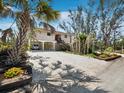 Lovely stilted home showcasing covered parking, and attractive landscaping near the beach and palm trees at 650 Penfield St, Longboat Key, FL 34228