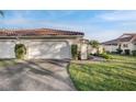 Well-manicured front yard with a two-car garage and tile roof at 7340 Golf Pointe Cir, Sarasota, FL 34243