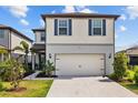 Inviting two-story home with a two-car garage, manicured lawn, and decorative blue shutters at 11419 Gallatin Trl, Parrish, FL 34219