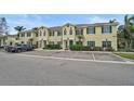 Inviting two-story townhome featuring green shutters, lush landscaping, and ample parking spaces at 208 Cape Harbour Loop # 108, Bradenton, FL 34212