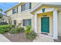 Charming townhouse featuring a vibrant green front door, well-maintained landscaping, and a welcoming entrance at 208 Cape Harbour Loop # 108, Bradenton, FL 34212