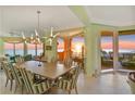 Elegant dining area with sunset view, modern light fixture, and seating for ten at 2141 Gulf Of Mexico Dr Unit # 4, Longboat Key, FL 34228