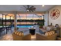 Screened-in patio with comfortable seating and a fire pit overlooking the pool and a lake view at 352 Chantilly Trl, Bradenton, FL 34212