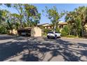 View of the parking area showing carports and guest parking in a lush, treed setting at 3810 75Th W St # 123, Bradenton, FL 34209