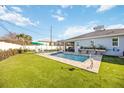 Inviting backyard featuring a sparkling pool, lush lawn, and charming outdoor decor at 432 W Gate Dr, Venice, FL 34285