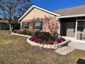 This home features stone-edged landscaping with a variety of colorful flower beds, bushes, and a stone walkway to the house at 4509 30Th Street E Cir, Bradenton, FL 34203