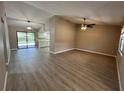 Open concept living room with ceiling fan, wood-look floors, and sliding doors to the pool area and kitchen at 4509 30Th Street E Cir, Bradenton, FL 34203