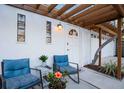 Cozy porch with seating, pergola, and white door provides a welcoming entrance at 5250 Calle De Rio, Sarasota, FL 34242