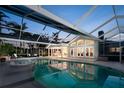 Sparkling pool surrounded by an enclosed lanai with tropical foliage and lots of lounging space at 721 Cadiz Rd, Venice, FL 34285