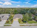 Aerial view of a single Gathering home with a three-car garage surrounded by lush trees and landscaping at 7911 Kavanagh Ct, Sarasota, FL 34240