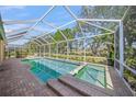 A screened-in swimming pool and hot tub with brick pavers offers a relaxing outdoor retreat at 7911 Kavanagh Ct, Sarasota, FL 34240