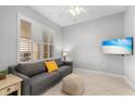 Cozy living room featuring plantation shutters, tile flooring, and a comfortable sofa at 147 Tampa E Ave # 702, Venice, FL 34285