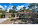 Lovely single-story home with a terracotta tile roof and mature landscaping at 1555 Flower Dr, Sarasota, FL 34239