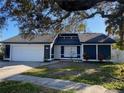 Charming single-story home featuring a two-car garage, fresh landscaping, and mature trees at 2900 Woodpine Ct, Sarasota, FL 34231