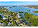 Breathtaking aerial view of waterfront home near the bay, nestled among lush greenery at 5236 Siesta Cove Dr, Sarasota, FL 34242