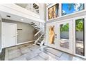 Bright foyer with elegant staircase, tile flooring and modern design accents at 5236 Siesta Cove Dr, Sarasota, FL 34242