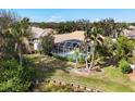 Aerial view of backyard, pool area and lush landscaping with waterfront view at 6922 Stanhope Pl, University Park, FL 34201