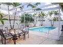 Screened-in pool area featuring a dining set and clear view of the backyard and palm trees at 7113 52Nd E Dr, Bradenton, FL 34203