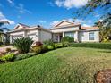 Inviting single-story home with a brick driveway, manicured lawn, and lush landscaping at 8284 Barton Farms Blvd, Sarasota, FL 34240