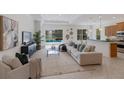 Bright living room featuring tile floors, large sectional sofa and access to a screened pool area at 11728 Strandhill Ct, Lakewood Ranch, FL 34202