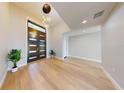 Bright foyer with light hardwood floors, pendant lighting, and an eye-catching front door at 1471 Palmwood Dr, Sarasota, FL 34232
