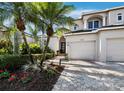 Well-manicured front yard with a paved walkway leading to the front entrance, featuring a two-car garage at 2065 Harbour Links Dr # 5, Longboat Key, FL 34228